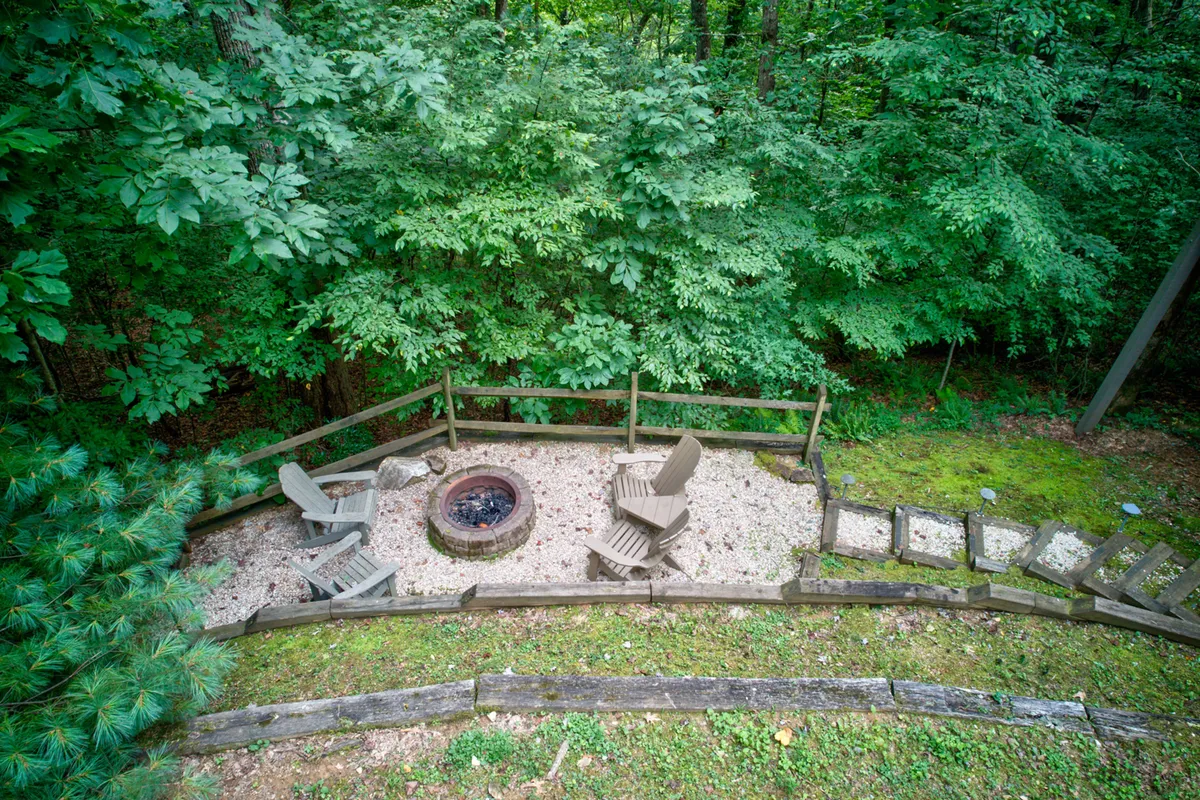 This image showcases a welcoming outdoor fire pit area, complete with surrounding seating and a clear pathway, designed for group gatherings. The relaxed setting is ideal for sharing stories, roasting marshmallows, and stargazing together.